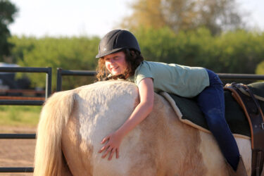 Kid riding a horse backwards